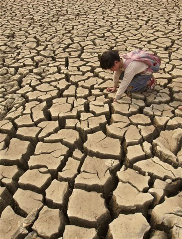 A girl plays on the dried bed of a reservoir in Qinglong county, in China's Guizhou province, Monday, March 22, 2010. The worst drought in decades in China's southern provinces of Yunnan, Guizhou, and Sichuan, as well as the Guangxi Autonomous Region and the city of Chongqing, has forced local governments to tap underground water sources and use cloud seeding to produce rain for agricultural production. (AP Photo) **  CHINA OUT **